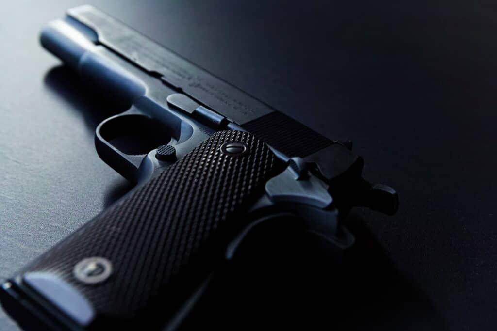 Close-up of a pistol on a dark surface, ideal for illustrating tips for first-time pistol shooters.